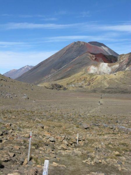 Our first glimpse of Mount Doom on the Tongariro crossing, with people walking along the trail in the distance