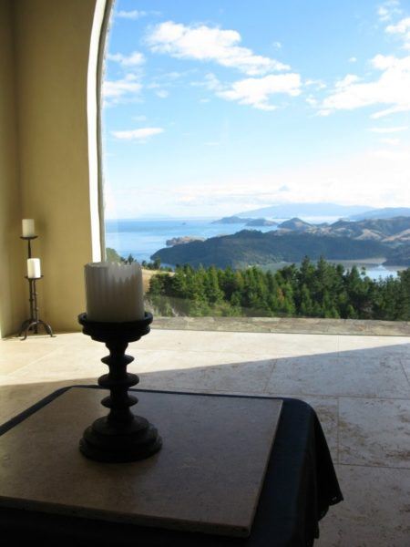 A candle on a table in front of a window inside the sanctuary