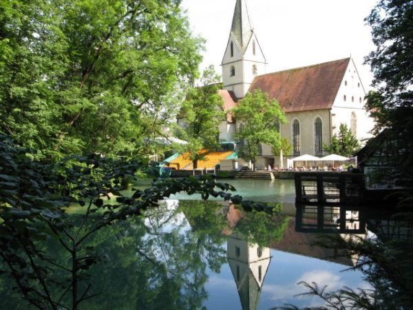 reflections of a church in a blue pond in Germany