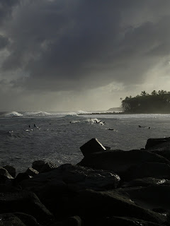 sun setting through a dramatic sky over the ocean