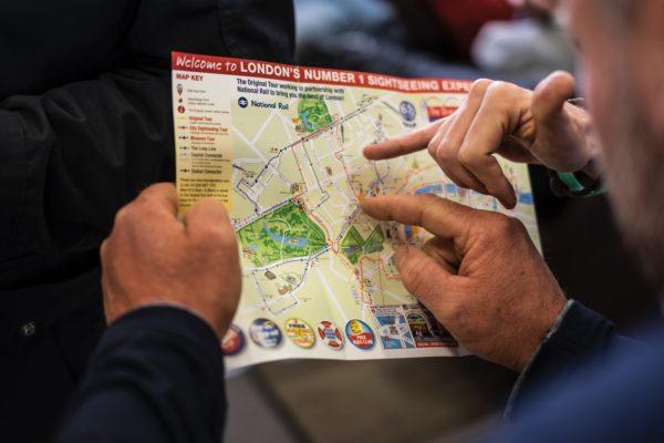 People pointing at London tour map - hidden travel costs
