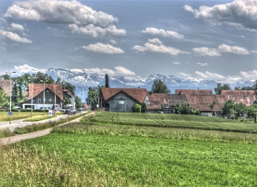 peaceful mountains of Switzerland with farmland in foreground