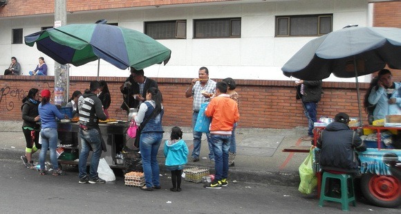 Fast food Colombia Street stands in Bogota with umbrellas 